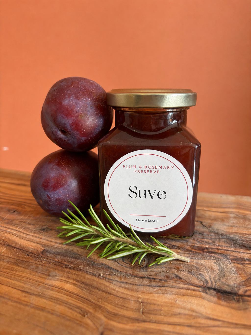 200 ml jar of plum and rosemary with fresh plums and fresh sprig of rosemary 